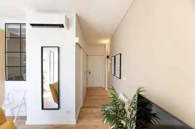 a hallway of a house with white walls and a mirror at Urban House by LovelyStay in Porto