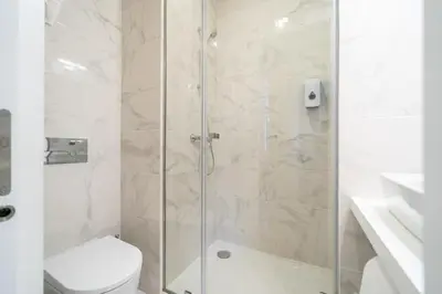 a bathroom with a glass shower with a toilet at Formosa Apartments by Amber Star Rent in Porto