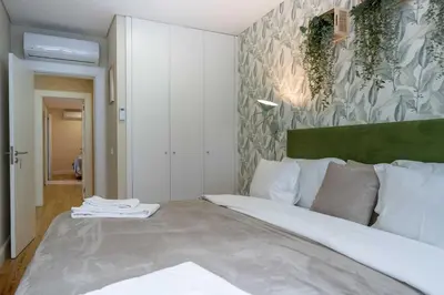 a bedroom with a large bed and a painting on the wall at Formosa Apartments by Amber Star Rent in Porto