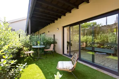 a patio with a table and chairs on the grass at Zen Garden Studio A in Porto