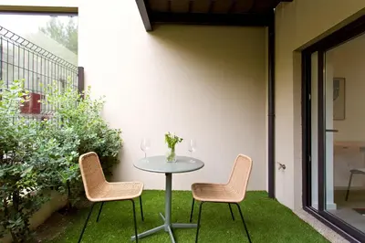 a table and chairs on a patio with grass at Zen Garden Studio D in Porto