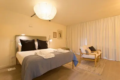 a bedroom with a bed and a ottoman at Zen Garden Studio C in Porto