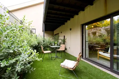 a kitchen with white cabinets and a wooden table and chairs at Zen Garden Studio C in Porto
