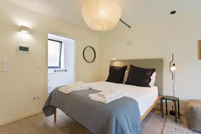 a bedroom with a bed and a window and a lamp at Zen Garden Studio C in Porto