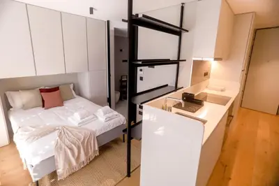 a small room with a bed and a desk at Alegria Suítes By Porto City Hosts in Porto