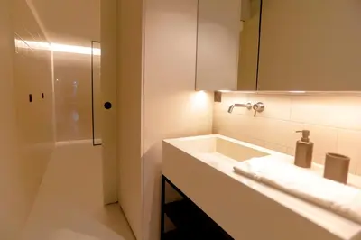 a bathroom with a sink and a mirror and a shower at Alegria Suítes By Porto City Hosts in Porto