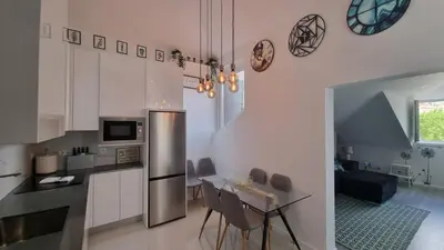 a kitchen with a table and a stainless steel refrigerator at LUXURY PENTHOUSE - River Gallery Art - View&Center in Vila Nova de Gaia