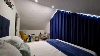 a bedroom with a bed and a window with blue curtains at LUXURY PENTHOUSE - River Gallery Art - View&Center in Vila Nova de Gaia