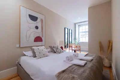 a bedroom with a large white bed with towels on it at Almada 1.3 by LovelyStay in Porto