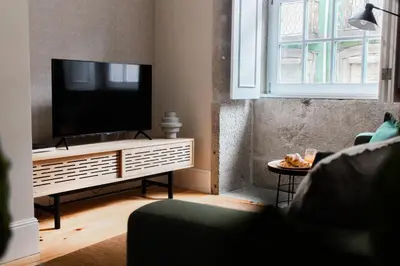 a living room with a flat screen tv on a stand at Almada 1.3 by LovelyStay in Porto