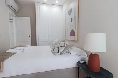 a white bedroom with a white bed and a lamp at Almada 1.3 by LovelyStay in Porto