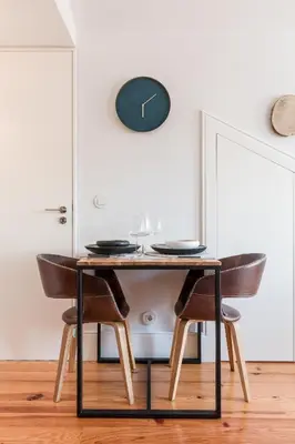 a dining room table with chairs and a clock on the wall at OPO Alegria 119 in Porto