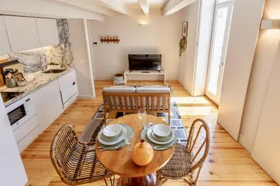 a kitchen and dining room with a wooden table and chairs at D&S - JB Apartments in Porto