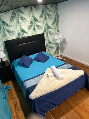 a bed with a towel on it with blue curtains at AL Pitões in Porto