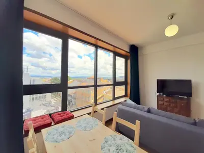 a living room with a couch and a table and a large window at Porto Vista II by Flat in Porto in Porto