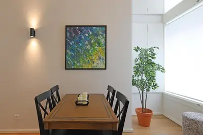 a dining room table with chairs and a painting on the wall at FLH Gaia Homey Winery Flat in Vila Nova de Gaia