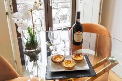 a glass table with a bottle of wine and a plate of food at Bright Studio near Douro River - with Balcony in Porto