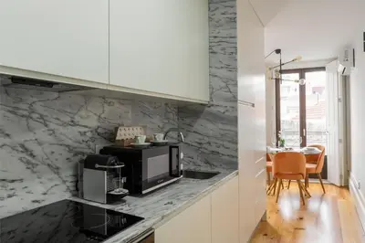 a kitchen with black and white marble counter tops at Bright Studio near Douro River - with Balcony in Porto
