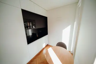 a dining room with a table and a tv on the wall at JARS Apartments - Casa do Bessa in Porto