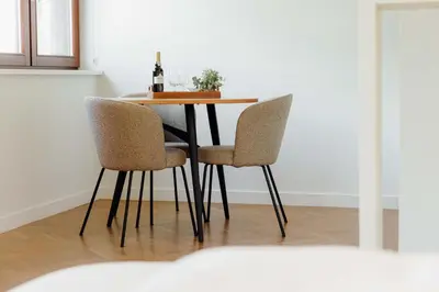 a dining room table with chairs and a bottle of wine at JARS Apartments - Casa do Bessa in Porto