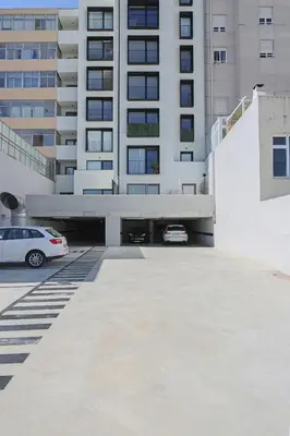 a parking lot in front of a tall building at HM - ISSY Oporto Apartment in Porto