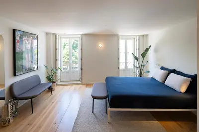 a bedroom with a blue bed and a chair at Gharb in Porto