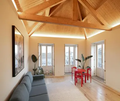 a living room with a blue couch and wooden ceilings at Gharb in Porto