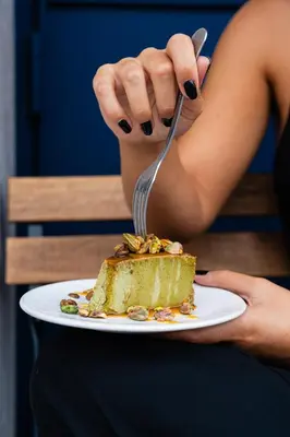 a person eating a piece of cake with a fork at Gharb in Porto