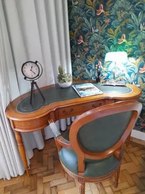 a desk with a chair and a clock on it at Cozy Central 3 Bedrooms Bragas in Porto
