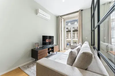 a living room with a couch and a tv at GuestReady - Modern Apartment in Bolhão in Porto