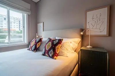 a bedroom with a bed with pillows and a window at Mauve Studio perto do Metro, Cedofeita, Porto in Porto