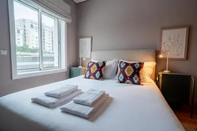 a bedroom with a bed with three towels on it at Mauve Studio perto do Metro, Cedofeita, Porto in Porto