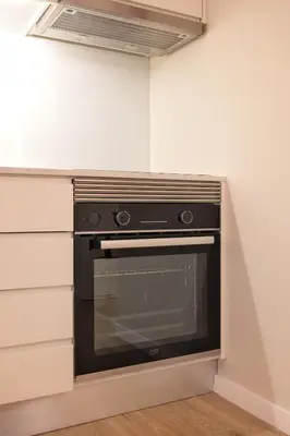 a kitchen with a black oven in a wall at Strelitzia Apartment, by Bolhão Residences in Porto