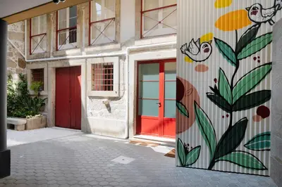 a building with a red door with a painting on it at Strelitzia Apartment, by Bolhão Residences in Porto