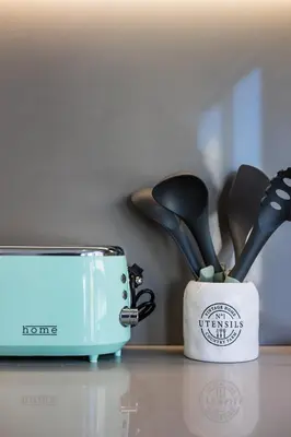a container of kitchen utensils next to a toaster at Pestana Apartments - Premium in Porto