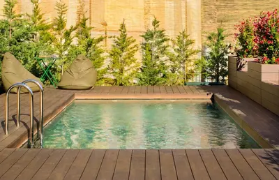 a small swimming pool in a garden with plants at 108MM House in Porto