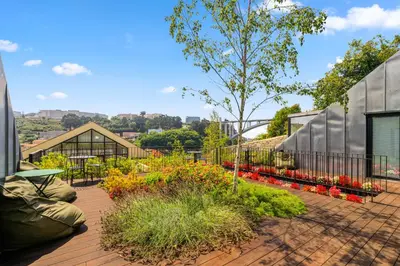 a patio with a garden with flowers and a building at 108MM House in Porto