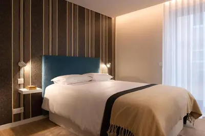 a bedroom with a large bed with a blue headboard at Wanderlust, by Bolhão Residences in Porto
