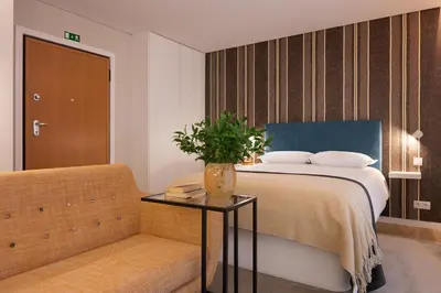 a bedroom with a bed with a table and a couch at Wanderlust, by Bolhão Residences in Porto