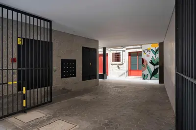 an empty hallway with doors and a wall with graffiti at Wanderlust, by Bolhão Residences in Porto