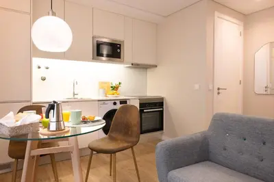 a kitchen with a table and a chair and a couch at Nomad Apartment, by Bolhão Residences in Porto