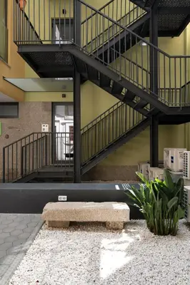 a bench in the middle of a building with a staircase at Nomad Apartment, by Bolhão Residences in Porto