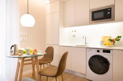 a kitchen with a table and a washing machine at Nomad Apartment, by Bolhão Residences in Porto