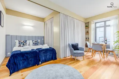 a bedroom with a bed and a table and chairs at Locally Yours Flores Apartments in Porto