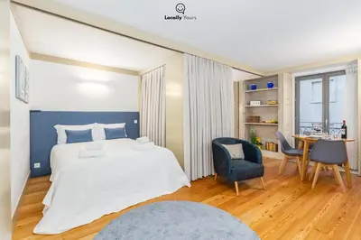 a bedroom with a bed and a table and chairs at Locally Yours Flores Apartments in Porto