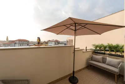 a patio with an umbrella and a chair on a balcony at Porta do sol Luxury Apartment in Porto