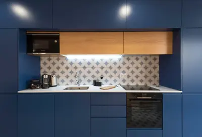 a blue kitchen with a sink and a microwave at Porta do sol Luxury Apartment in Porto
