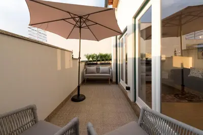 a patio with an umbrella and a chair and a couch at Porta do sol Luxury Apartment in Porto