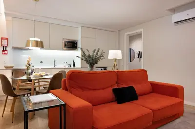 a living room with a red couch and a table at Byobu Apartment, by Bolhão Residences in Porto