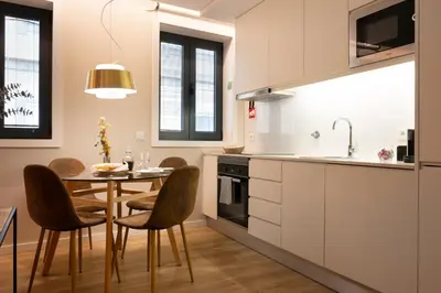 a kitchen with a table and chairs and a dining room at Byobu Apartment, by Bolhão Residences in Porto